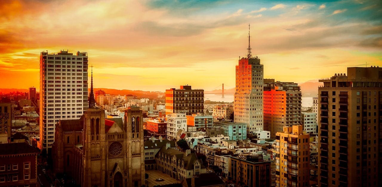 downtown san francisco, the golden gate bridge in the background, near sunset